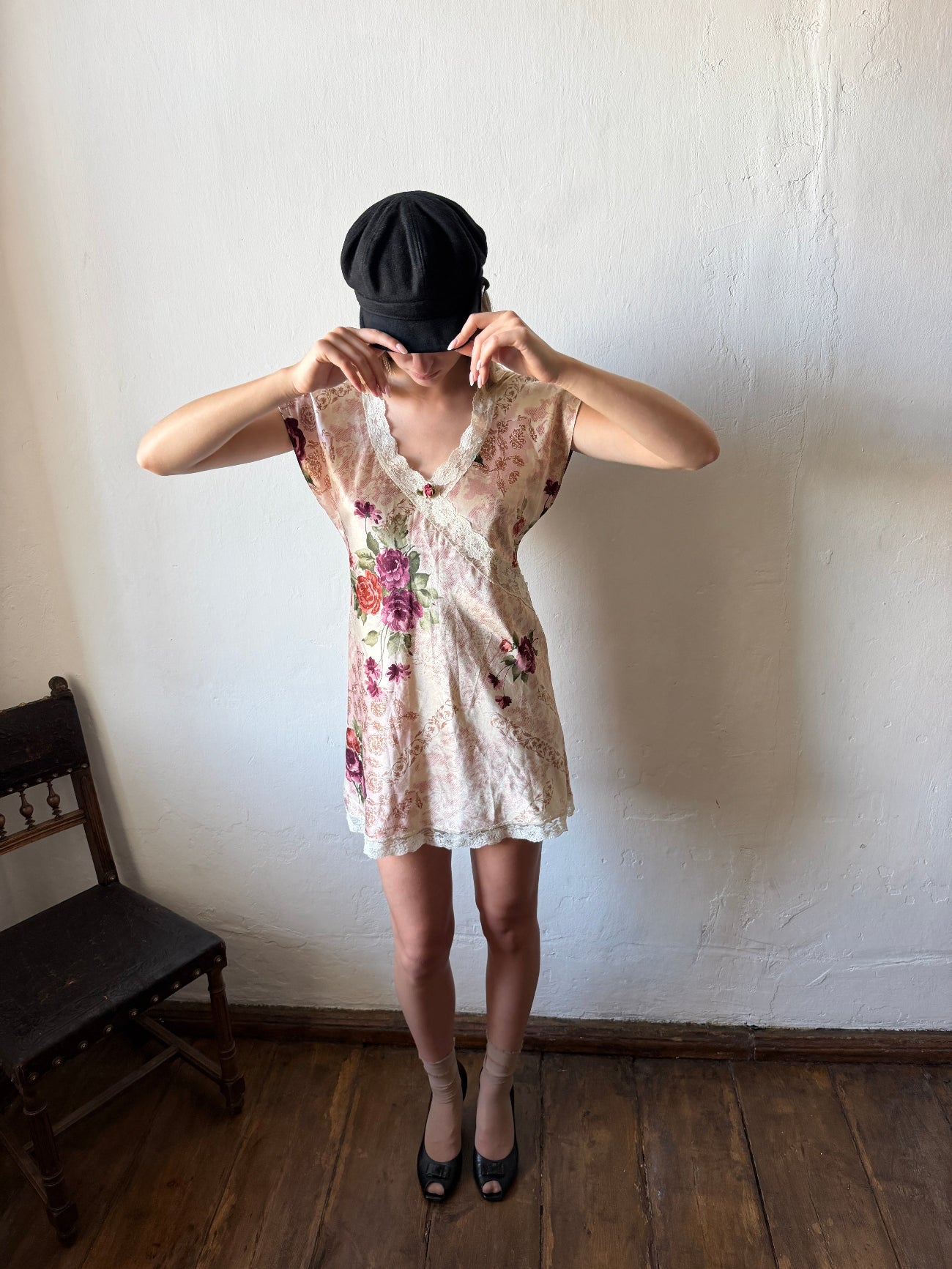 model is wearing a short floral lace dress and a black beret 