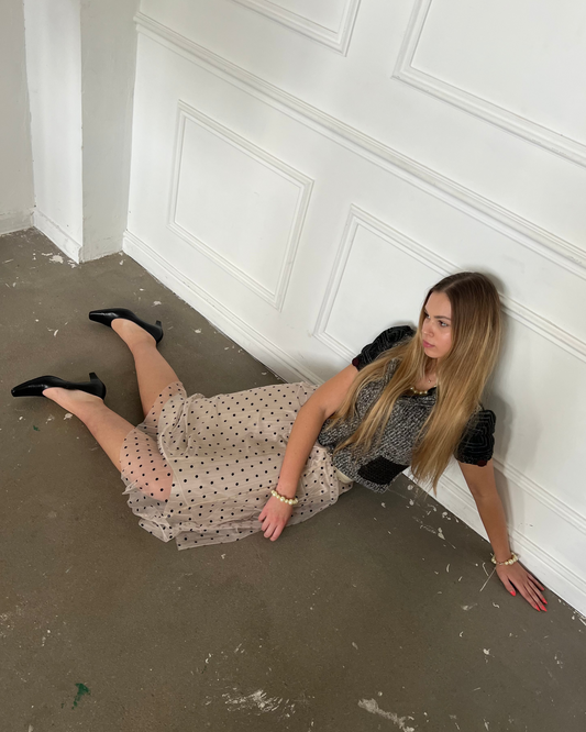 Woman sitting on the floor against a white paneled wall